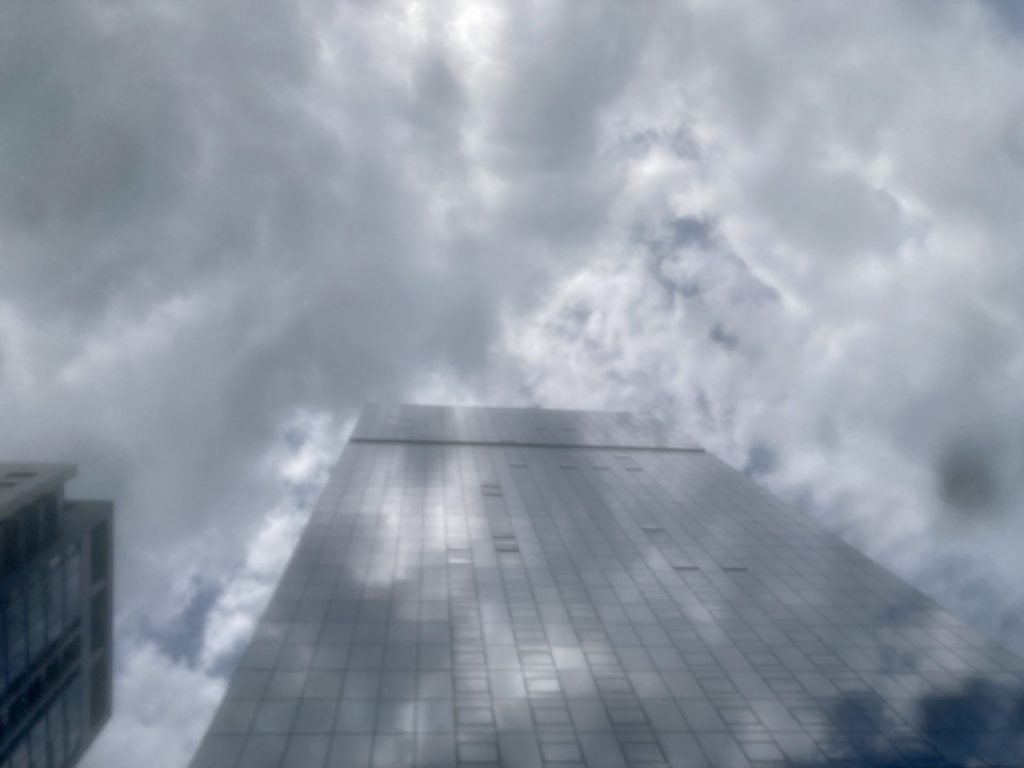 Photo of Otima I tower by David Hovey viewed from street level with cloudy skies above it.